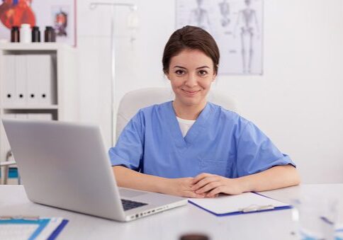 Altura Learning Portrait of medical practitioner nurse looking into camera smiling sitting at desk in conference meeting room. Confident physician asisstant analyzing pills treatment expertise on laptop computer