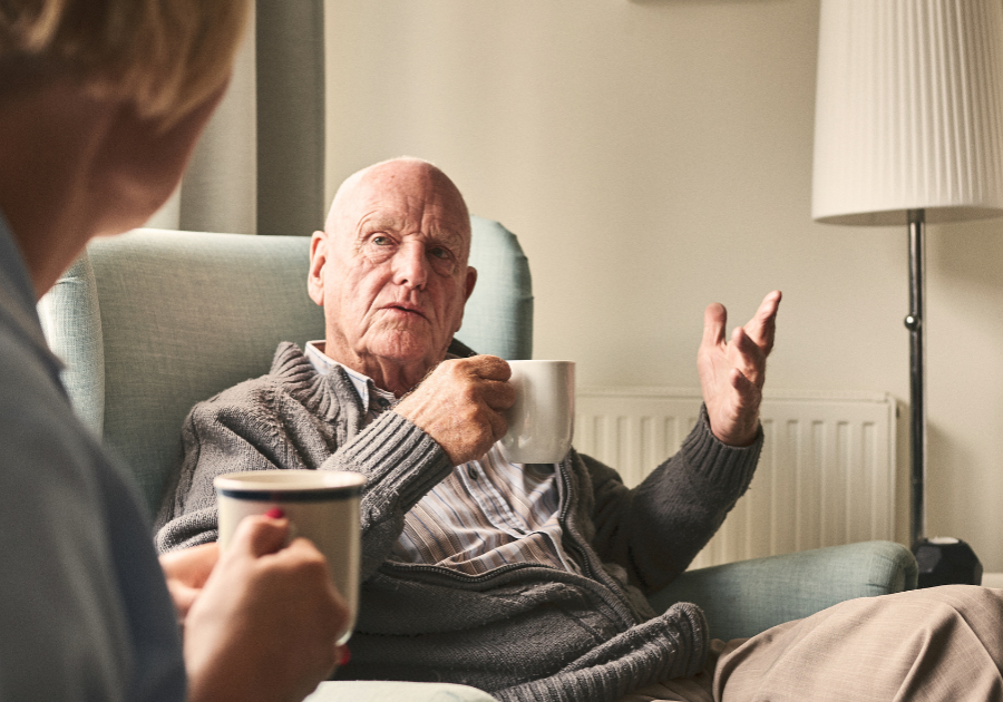 Elderly male speaking with carer