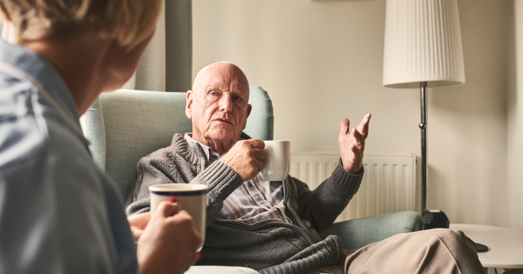 Elderly male speaking with carer